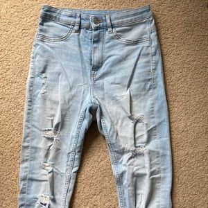 H&M Light Wash Blue Jeans. Ripped with silver buttons. Pockets in back. Size 2.